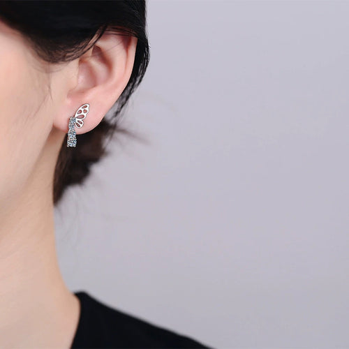 Butterfly Moissanite Stud Drop Earrings in Rhodium-Plated S925 sterling silver worn on ear by model showing scale, placement, and stud earrings styling