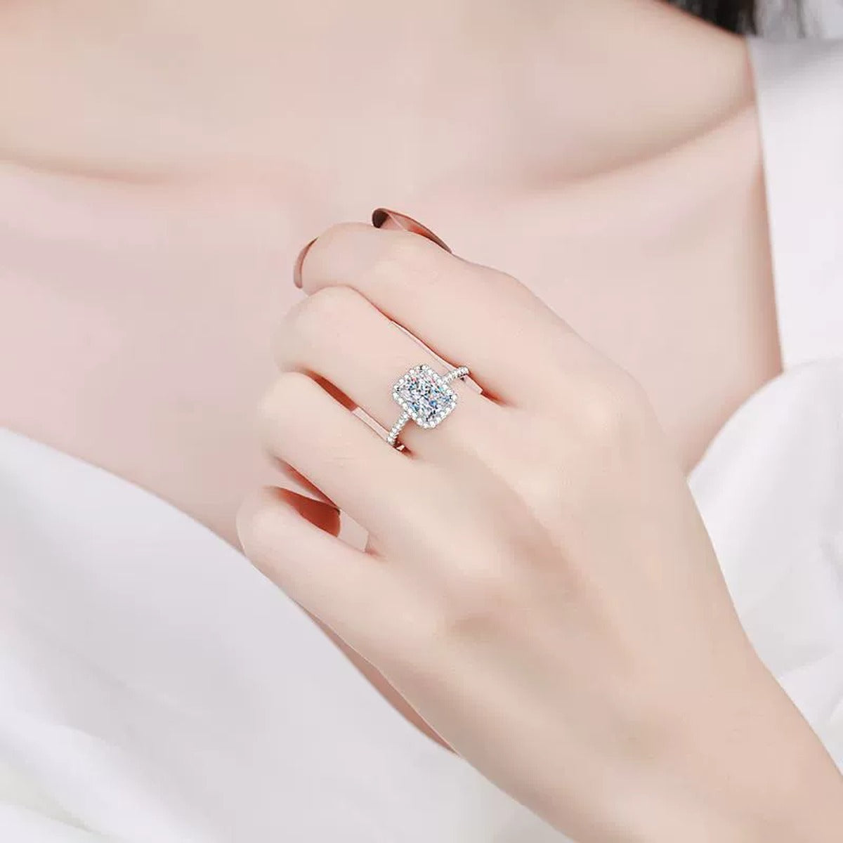 Emerald Cut Moissanite Halo Ring with CZ worn on hand to show scale and ring profile