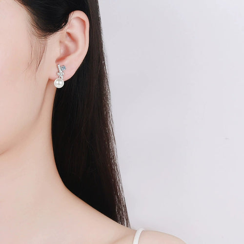 Bow Pearl Moissanite Stud Drop Earrings in Rhodium-Plated S925 sterling silver worn on ear by model showing scale, placement, and stud earrings styling