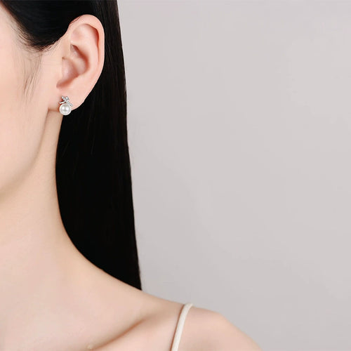 Bow Pearl and Moissanite Stud Dangle Earrings with CZ in Rhodium-Plated S925 sterling silver worn on ear by model showing scale, placement, and stud dangle earrings styling