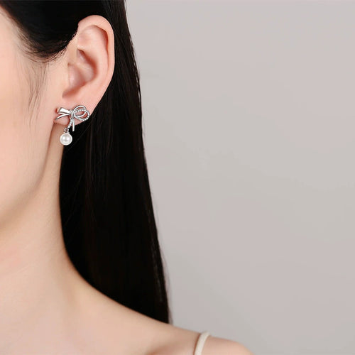 Bow Pearl and Moissanite Stud Dangle Earrings in Rhodium-Plated S925 sterling silver worn on ear by model showing scale, placement, and stud dangle earrings styling