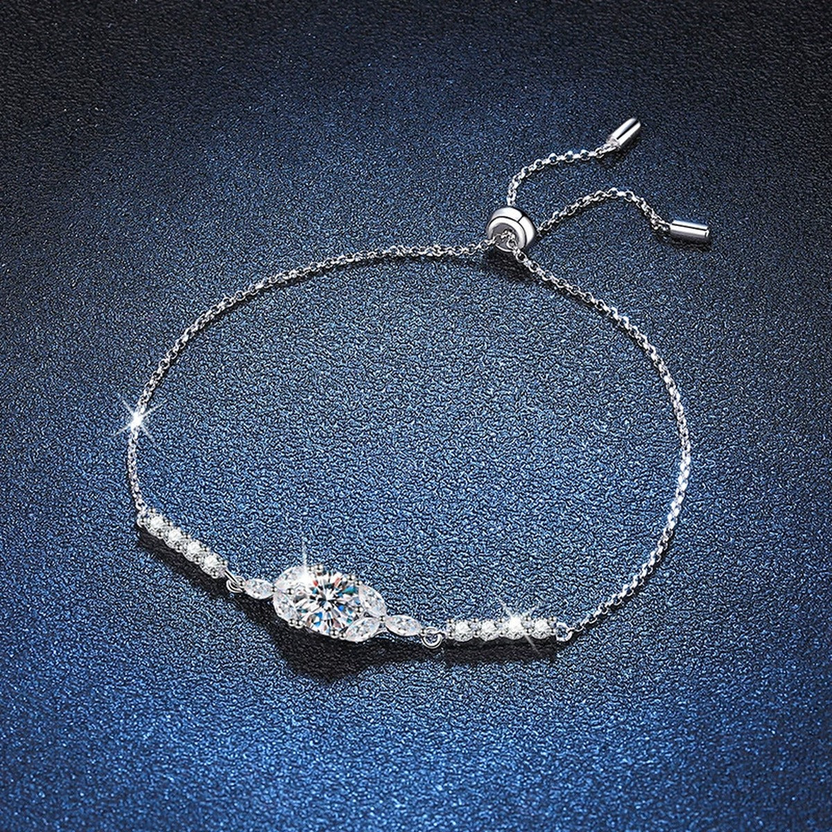 Oval Moissanite Adjustable Station Bracelet with CZ styled on blue display background with visible moissanite sparkle