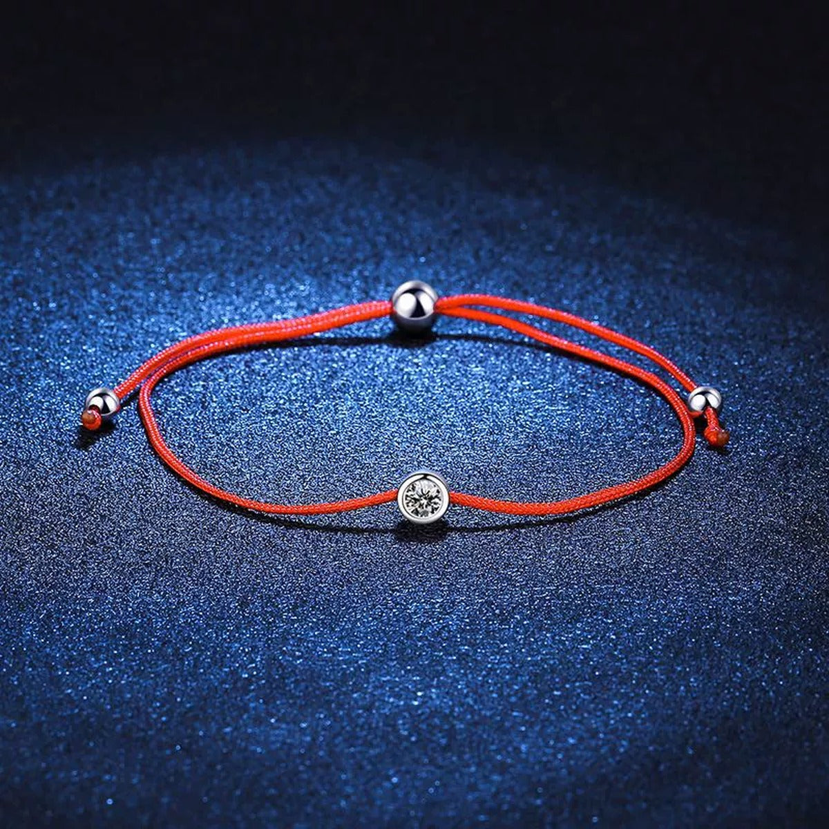 Red Cord Moissanite Adjustable Bracelet styled on blue display background with visible moissanite sparkle