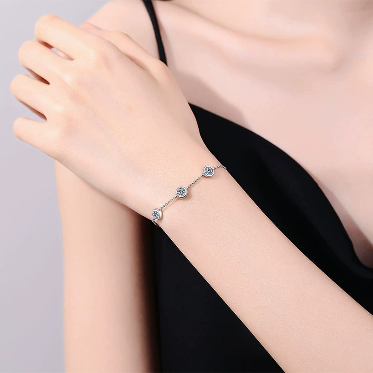 Three-Stone Moissanite Adjustable Station Bracelet worn on wrist by model showing scale and bracelet fit