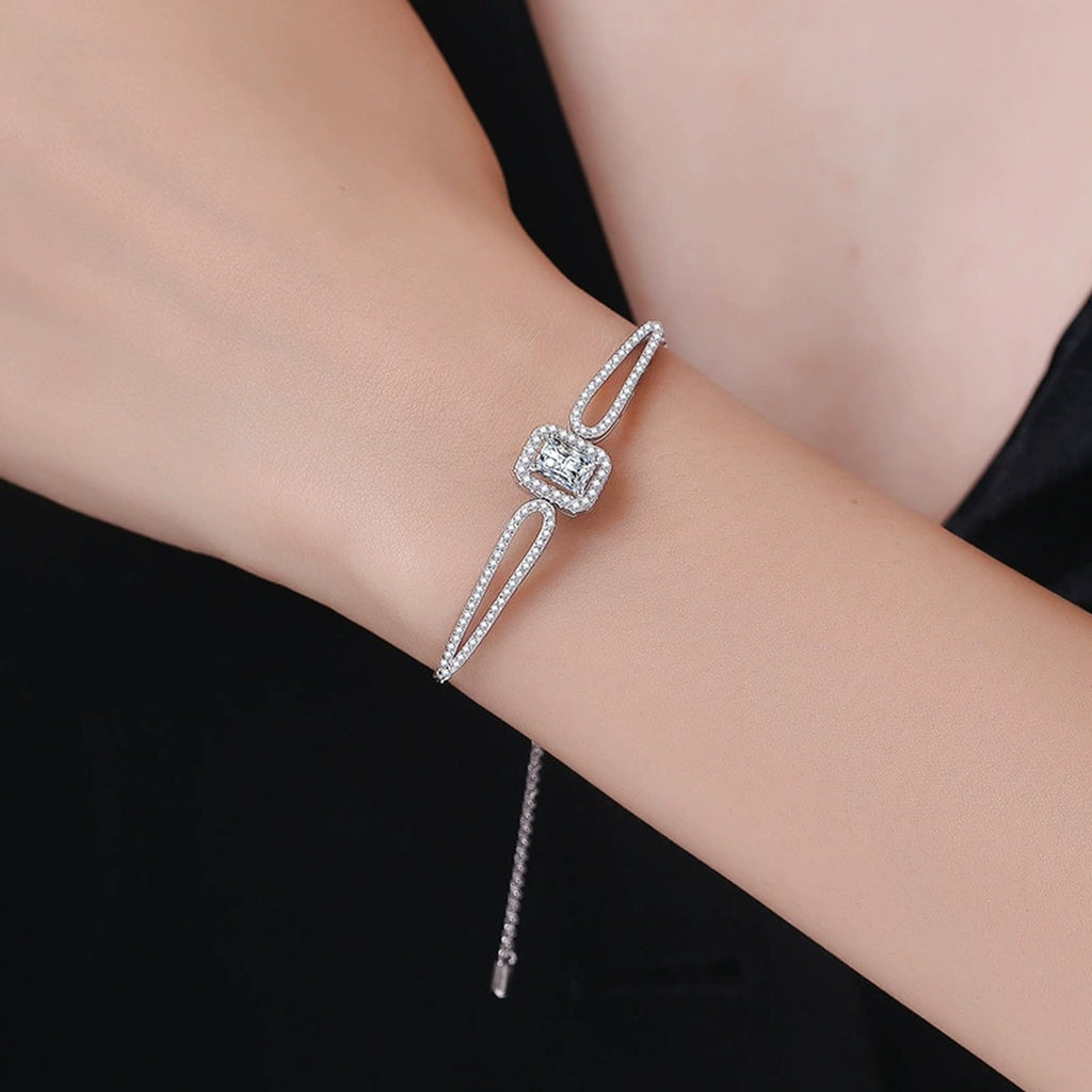 Pear Moissanite Adjustable Bangle Bracelet with CZ styled on blue display background showing moissanite sparkle
