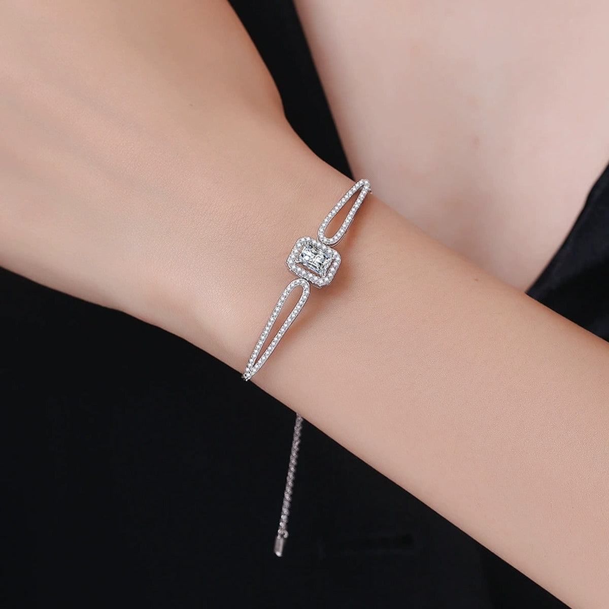 Pear Moissanite Adjustable Bangle Bracelet with CZ styled on blue display background showing moissanite sparkle