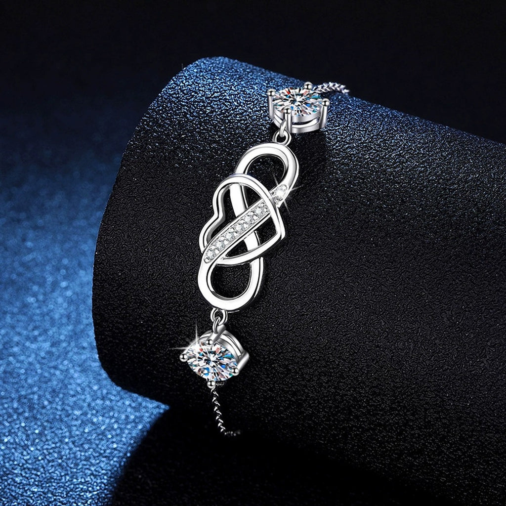 Infinity Heart Moissanite Chain Bracelet with CZ styled on blue display background showing moissanite sparkle