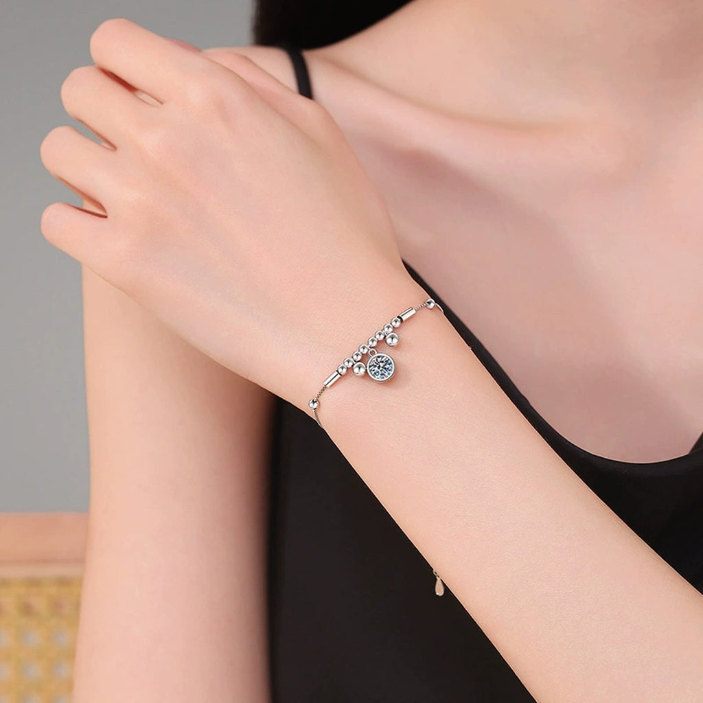 Round Moissanite Charm Bracelet worn on wrist by model showing bracelet scale and fit