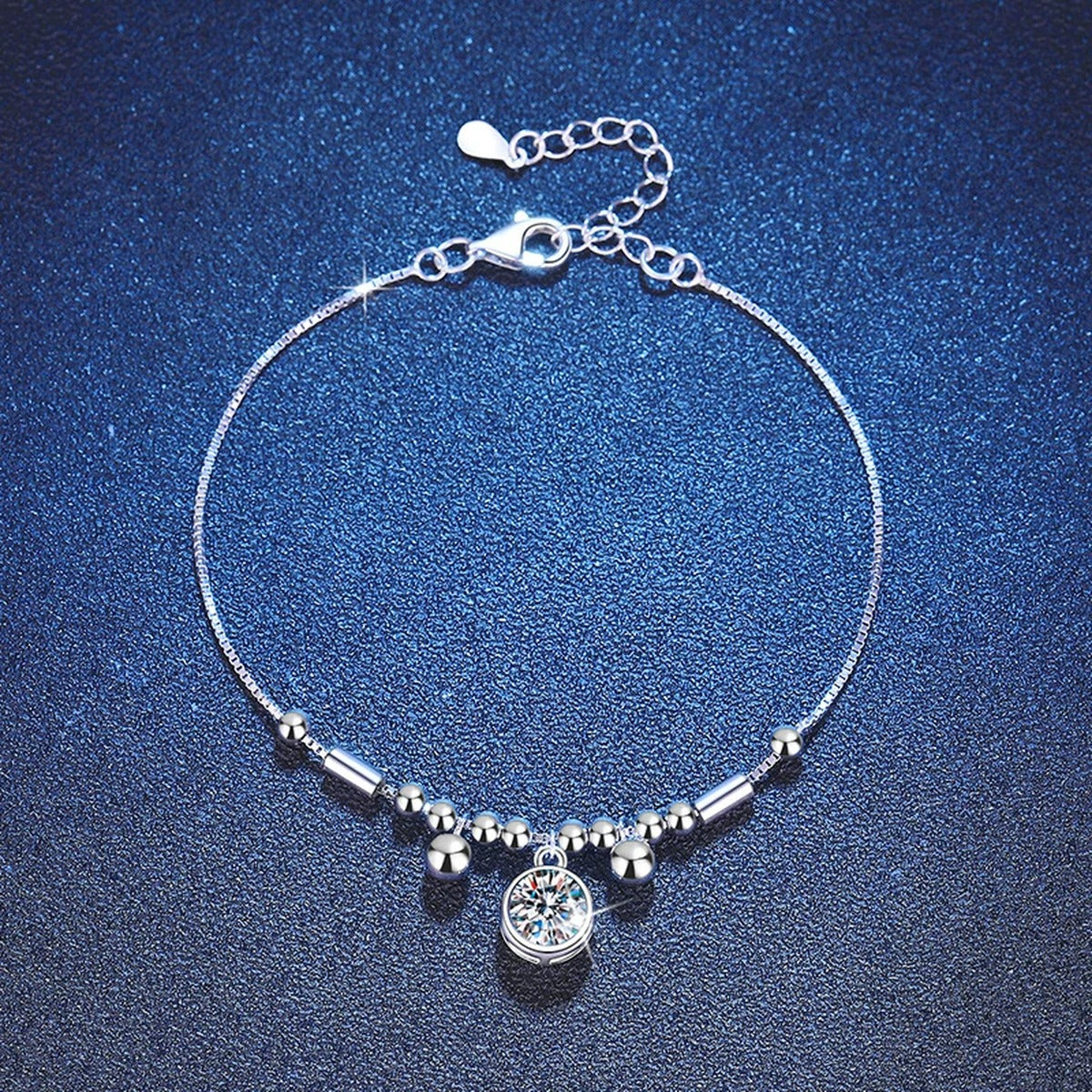 Round Moissanite Charm Bracelet styled on blue display background showing moissanite sparkle