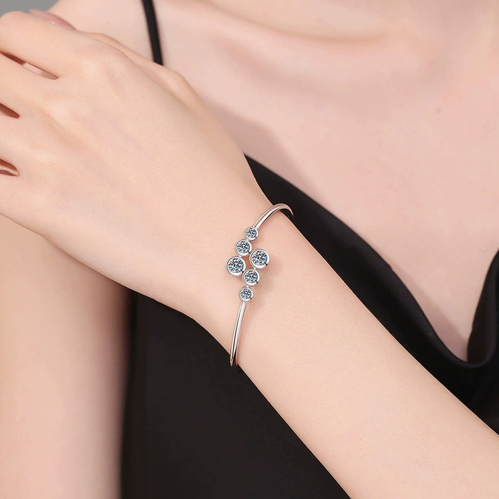 Three-Stone Moissanite Bangle Bracelet worn on wrist by model showing bracelet scale and fit