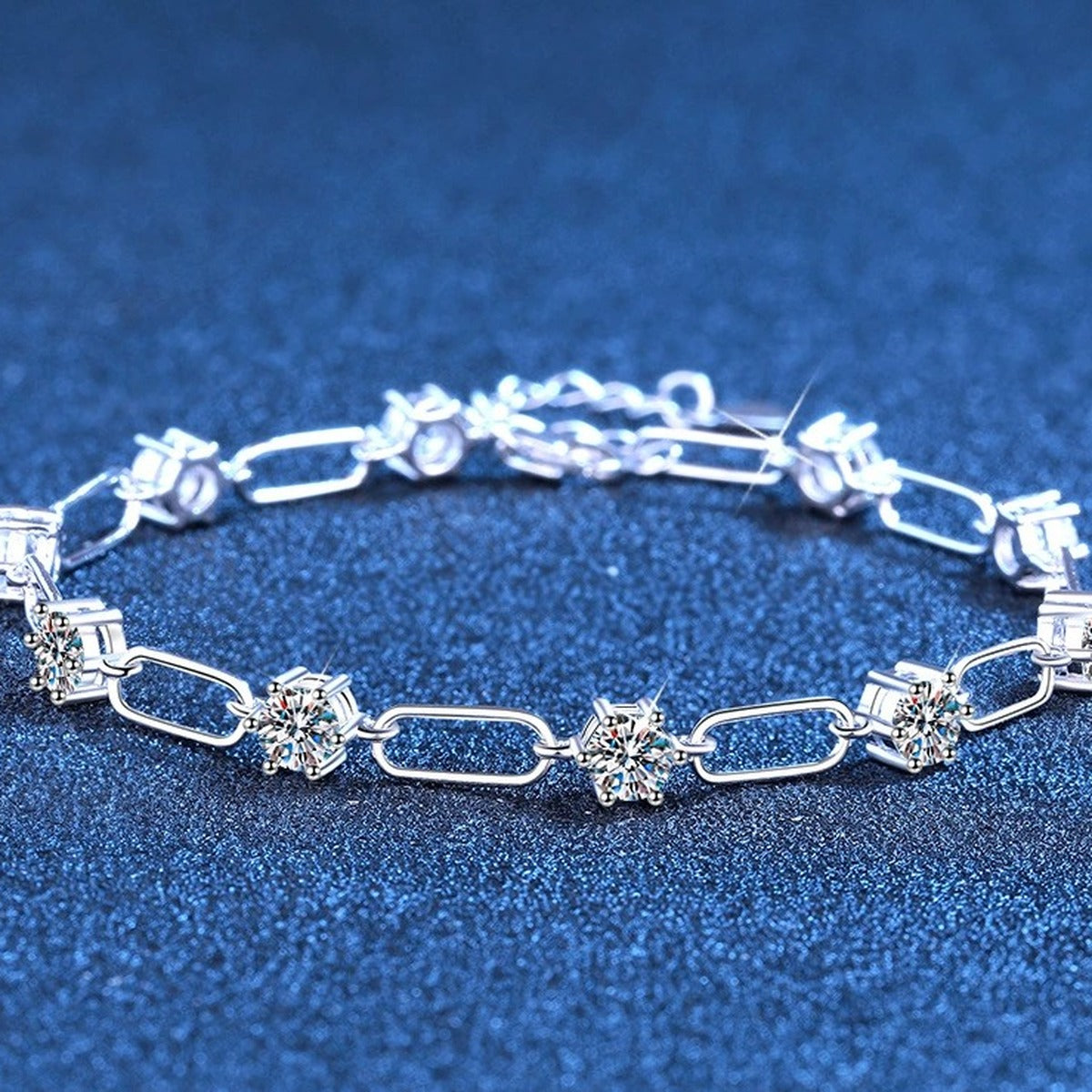 Three-Stone Moissanite Chain Bracelet styled on blue display background showing moissanite sparkle