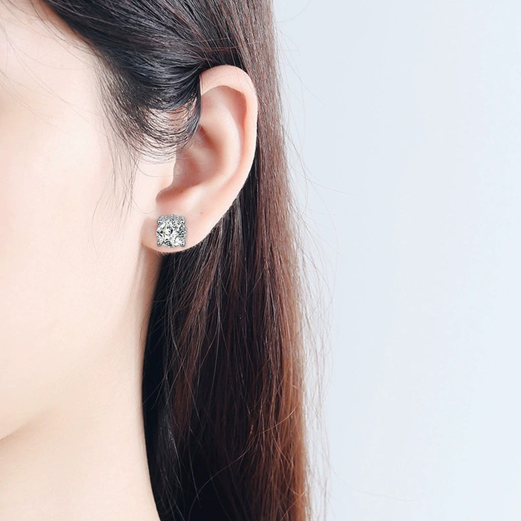 Four-Prong Round Moissanite Solitaire Stud Earrings in White Gold-Plated S925 sterling silver worn on ear by model showing scale, placement, and stud earrings styling