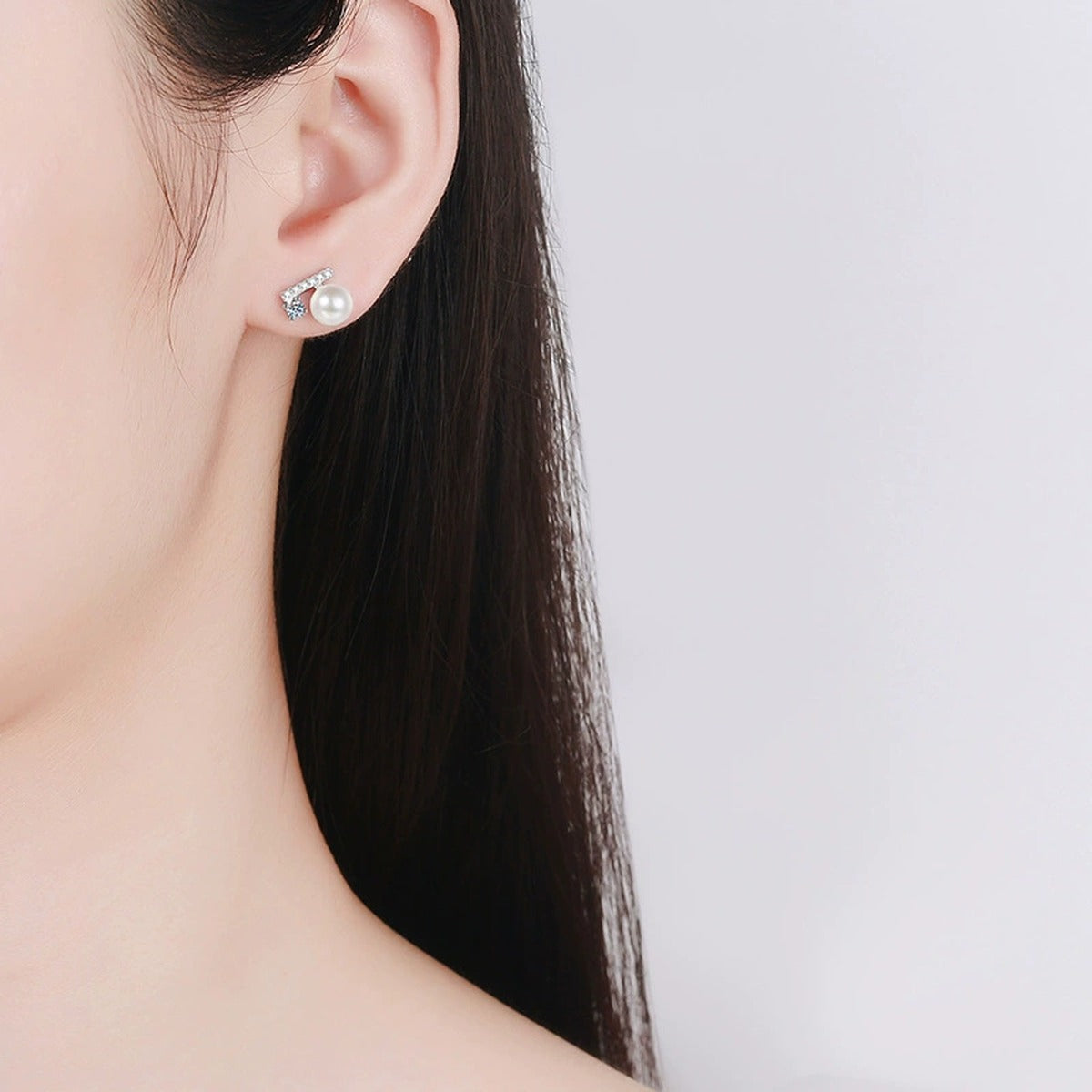 Geometric Round Moissanite and Pearl Stud Earrings with CZ in White Gold-Plated S925 sterling silver worn on ear by model showing scale, placement, and stud earrings styling