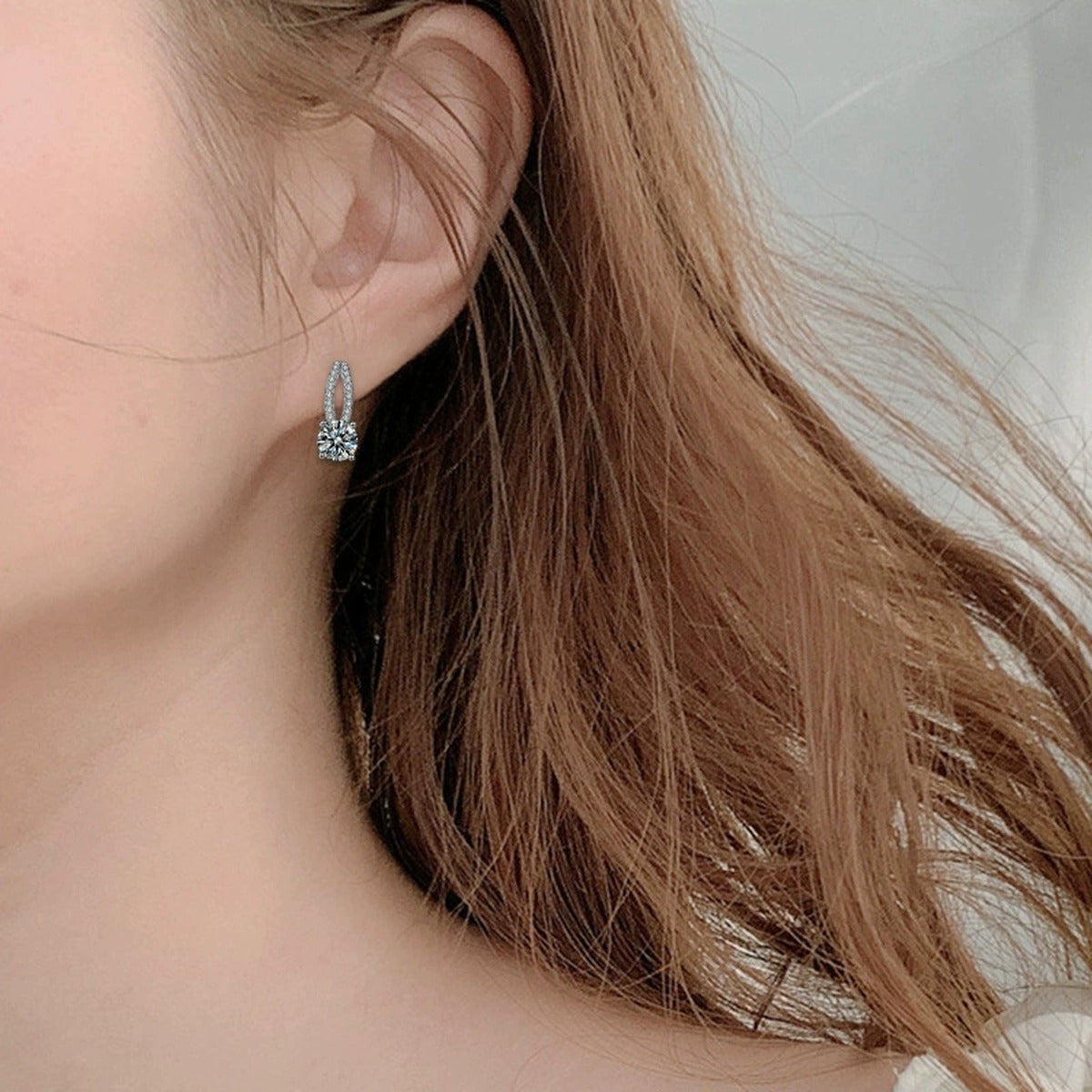 Curved Pave Round Moissanite Stud Drop Earrings with CZ in White Gold-Plated S925 sterling silver worn on ear by model showing scale, placement, and stud earrings styling