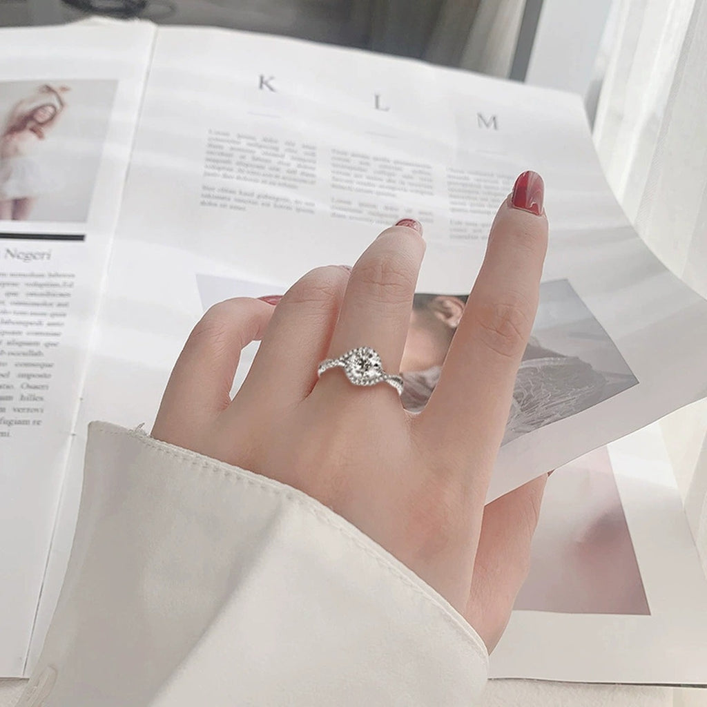 Twist Band Round Moissanite Engagement Ring with CZ worn on hand to show scale, band width, and ring profile