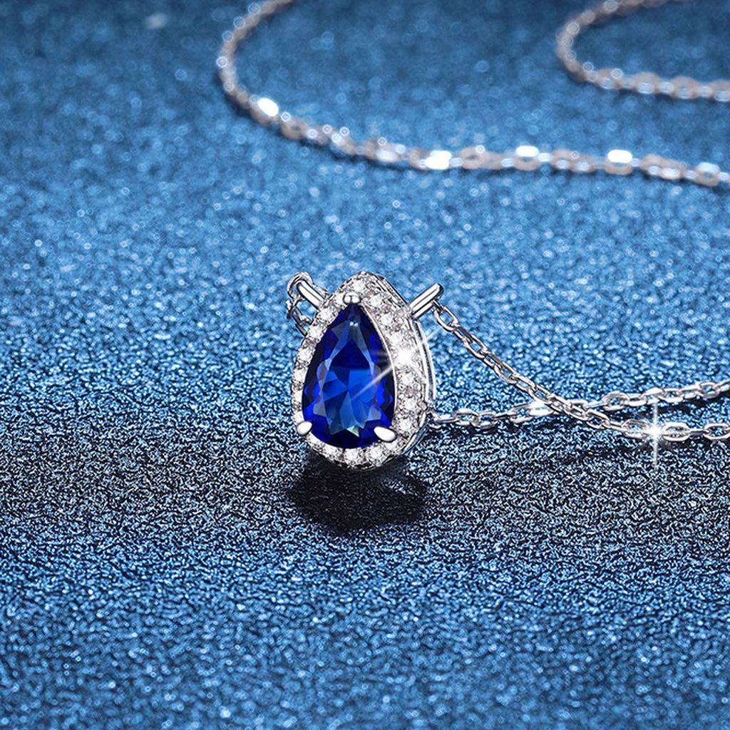 Pear Lab-Grown Gemstone and Moissanite Pendant Necklace in White Gold-Plated S925 Sterling Silver blue background angled view