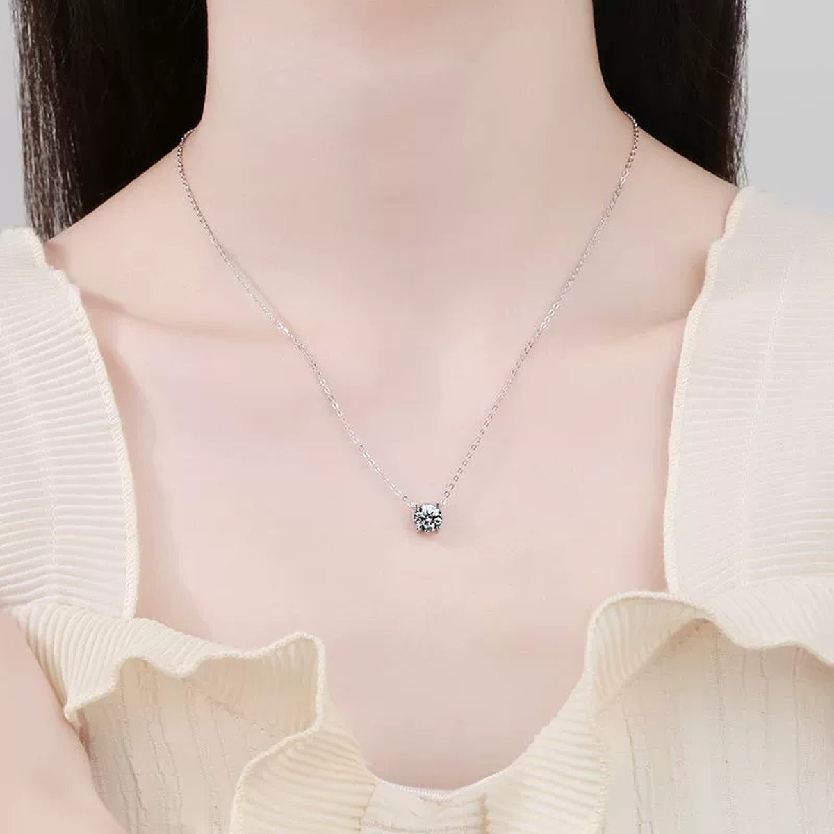 Round Moissanite Solitaire Pendant Necklace in Platinum-Plated S925 Sterling Silver worn by model at neckline