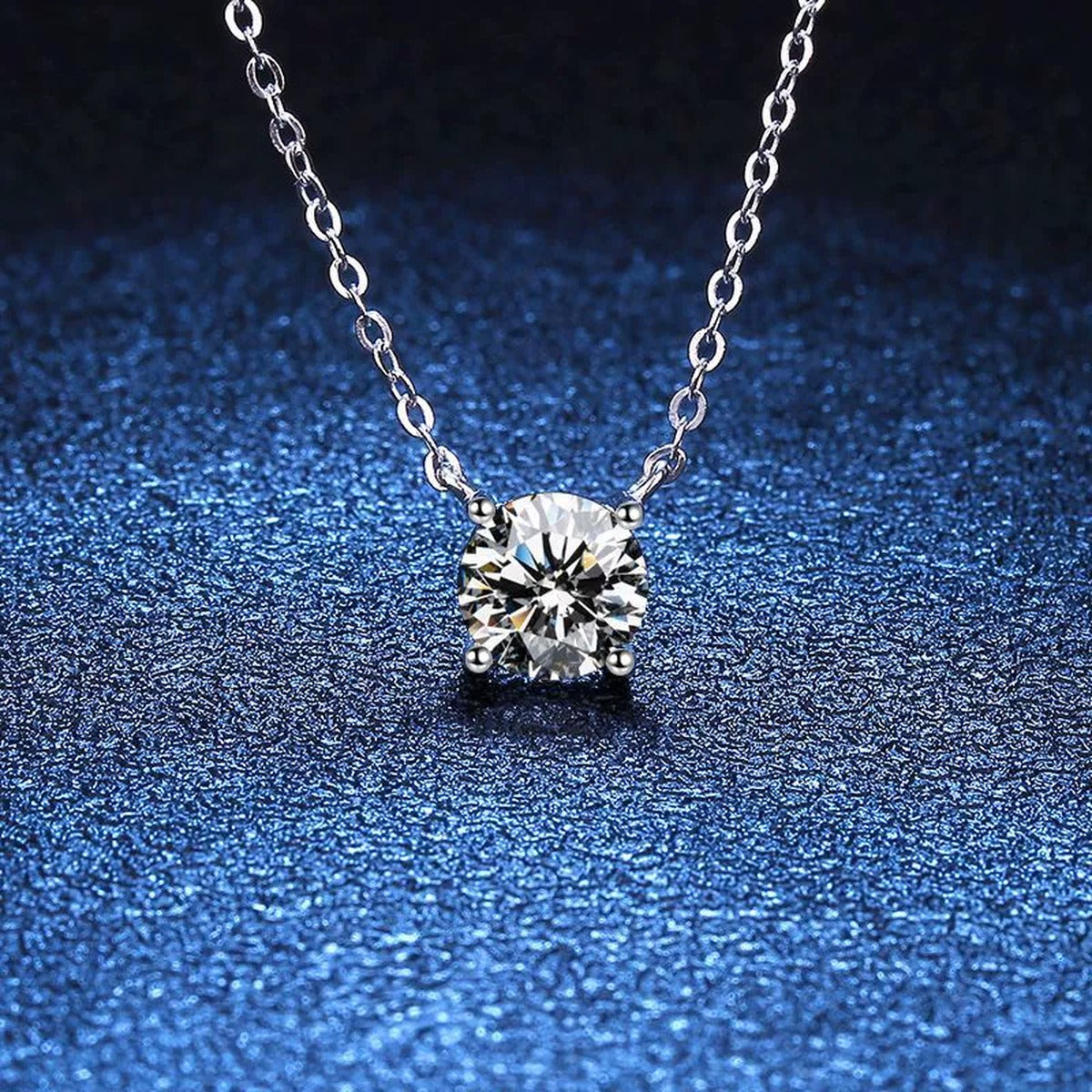 Round Moissanite Solitaire Pendant Necklace in Platinum-Plated S925 Sterling Silver blue background angled detail view