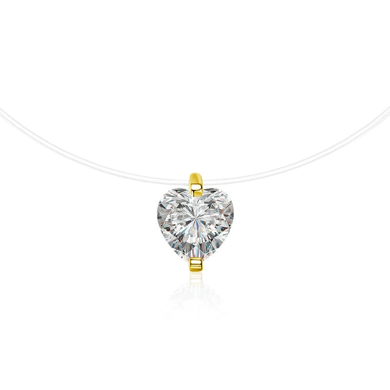 A heart-shaped clear moissanite pendant in a yellow gold setting, suspended from a delicate white cord against a white background.